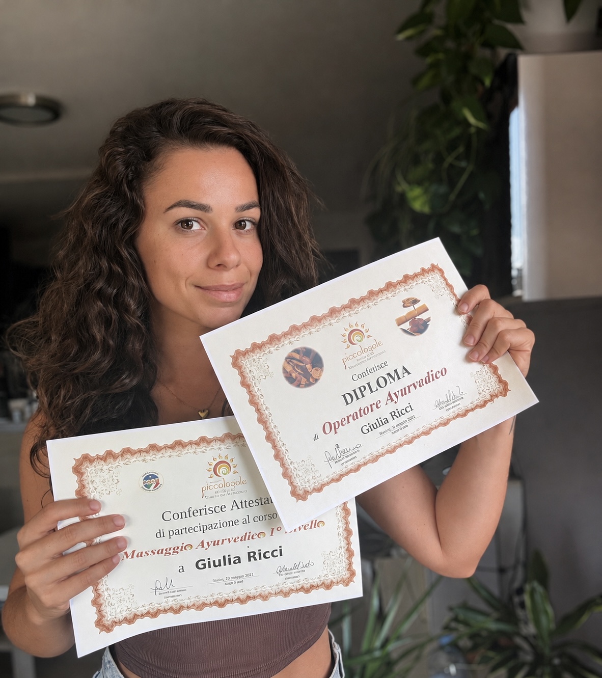 Giulia con sus diplomas de terapias ayurvédicas